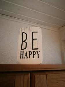 a sign that says be happy sitting on top of a shelf at Gartenblick in Zingst