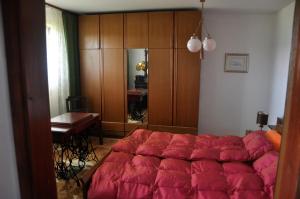 1 dormitorio con 1 cama grande y edredón rojo en Apartments MM en Muta