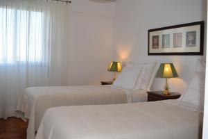2 Betten in einem weißen Zimmer mit 2 Lampen in der Unterkunft Vistas Sobre O Rio Tejo in Lissabon