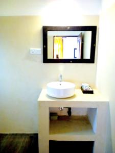 een badkamer met een witte wastafel en een spiegel bij Sleepy Head Guesthouse in Unawatuna