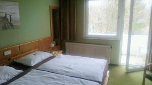 a bedroom with a bed and a large window at Pension Frühwirth in Bad Tatzmannsdorf