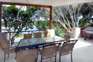a glass table and chairs on a patio at Wooli Holiday Units in Wooli