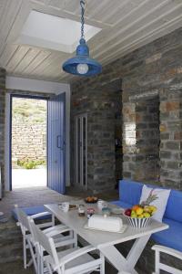 a dining room with a blue couch and a table at Bioclimatic stone built villa in Kastrianí