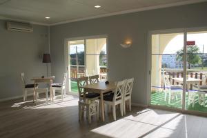 a dining room with a table and chairs and windows at Villa Welwitshia in Carvoeiro