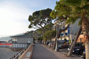 a street with palm trees and a building on the sidewalk at Residence Costa Templada in Ventimiglia
