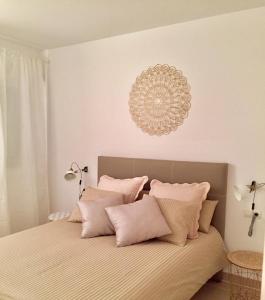 リンコン・デ・ラ・ビクトリアにあるMar y golfのベッドルーム1室(ピンクの枕とシャンデリア付きのベッド1台付)