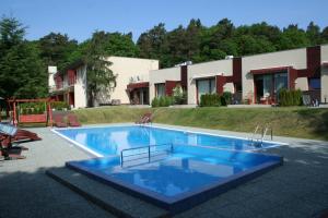 a large swimming pool in front of a house at Apartamenty Wisełka in Wisełka