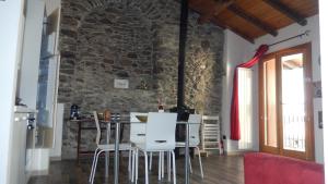 comedor con mesa, sillas y pared de piedra en La casa del ciodo, en Colico