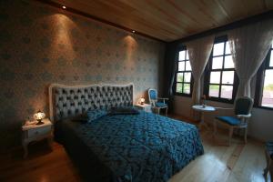 a bedroom with a bed and two chairs and windows at Esans Hotel - Special Category in Istanbul
