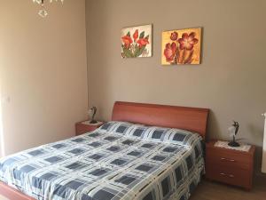 um quarto com uma cama e duas fotografias na parede em Gli Agrumi em Giustenice
