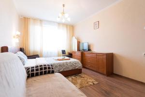 1 dormitorio con 1 cama, TV y sofá en FortEstate Profsoyuznaya 97 en Moscú