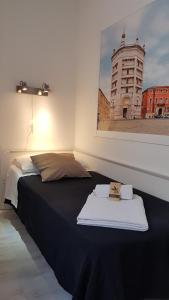 Un dormitorio con una cama con un cuadro en la pared. en ForumGuestHouse Center Parking, en Parma