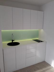 a kitchen with white cabinets and a sink at Apartman Senjak in Pirot