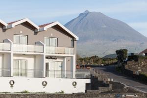 a house with a mountain in the background at Vila Barca in Madalena