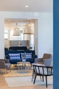 a living room with a blue couch and chairs at Falkensteiner Hotel Park Punat in Punat