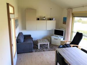 - un salon avec un canapé et une télévision dans l'établissement Huisje Zeegenoegen Oostduinkerke-Koksijde, à Coxyde