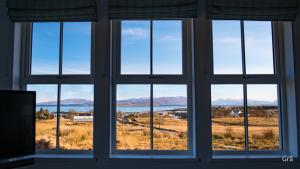 a window with a view of a field and mountains at Dark Skye Cottage in Broadford