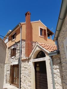 a building with a door and a brick tower at Apartmani Krapanj in Krapanj