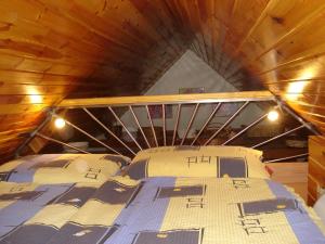 uma cama num quarto com tecto em madeira em chatka em Rajecké Teplice
