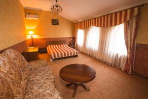 a living room with a couch and a table at Magnat Lux Hotel in Chernivtsi