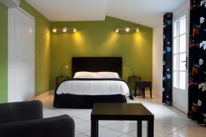 カルカソンヌにあるオテル ド ロクトロワの緑の壁、ベッド付きのベッドルーム1室