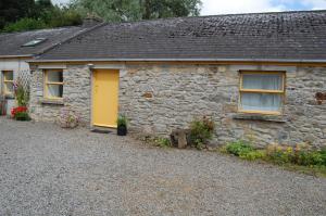 スライゴにあるArdtarmon Barn Cottageの石造りのコテージ 黄色いドア付