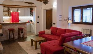 Il comprend un salon avec un canapé rouge et une cuisine. dans l'établissement Villa Jades Sardinia, à San Gregorio
