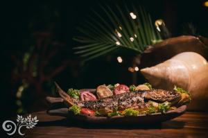 a dish of food on a plate on a table at Paua Hotel Boutique in Pipa