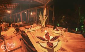 a wooden table with plates and glasses on it at Paua Hotel Boutique in Pipa