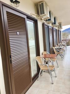 a row of chairs and tables on a balcony at Platanos Rooms in Anopoli Sfakion