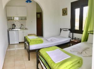 a room with two beds and a kitchen with a sink at Platanos Rooms in Anopoli Sfakion