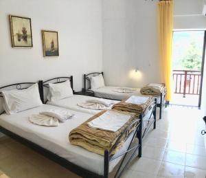 a group of three beds in a room at Platanos Rooms in Anopoli Sfakion