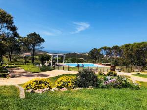 a park with a swimming pool and flowers at Herdade Monte Do Sol in Aljezur