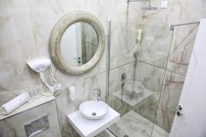 een badkamer met een douche, een wastafel en een spiegel bij Sunny Hill Garden in Stara Pazova