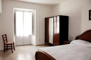 a bedroom with a bed and a dresser and a chair at Casa Allegra e Colorata in Badolato