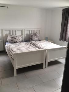 a white bed with two pillows on top of it at Ferienwohnung Stricker in Birken-Honigsessen
