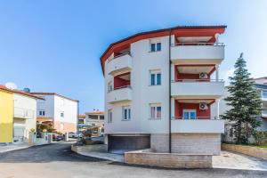 a white building with a red roof at Apartman KP in Medulin