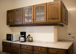 a kitchen with wooden cabinets and a coffee maker on a counter at Origami Porto Residência & Hostel in Vila Nova de Gaia
