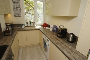 a kitchen with a sink and a washing machine at M&N Central Apartment in Plovdiv +2 photos