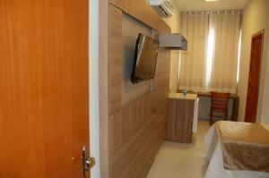 a room with a door with a television and a bed at Hotel Royal in Salinas