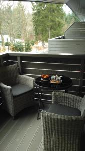 un patio con 2 sillas y una mesa con comida. en Harrachov Resident Apartments with Terrace en Harrachov