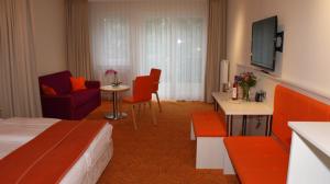 グラール・ミューリッツにあるHotel Waldperleのベッドとリビングルームが備わるホテルルームです。