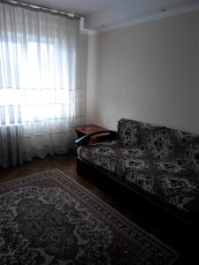 een woonkamer met een bank en een raam bij Comfortable flat near the Dnieper river in Kyiv in Kiev