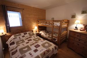 a bedroom with two bunk beds and a window at LES SAISIES - LA PERLE DES ALPES in Les Saisies