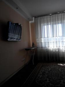 uma sala de estar com televisão e janela em Comfortable flat near the Dnieper river in Kyiv em Kiev