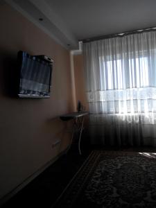 a living room with a television and a window at Comfortable flat near the Dnieper river in Kyiv in Kyiv