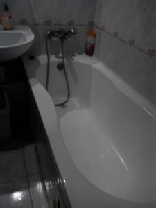 y baño con bañera blanca y lavamanos. en Comfortable flat near the Dnieper river in Kyiv, en Kiev
