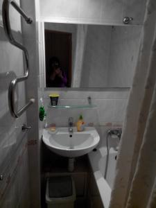 kobieta robiąca zdjęcie łazienki z umywalką w obiekcie Comfortable flat near the Dnieper river in Kyiv w Kijowie