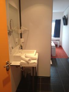 uma casa de banho com um lavatório e um espelho em HB1 Budget Hotel - contactless check in em Wiener Neudorf
