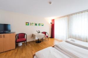 a hotel room with two beds and a television at Hotel Krone in Buochs